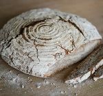 Ein angeschnittener Laib Brot auf einem Brett