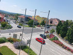 Straßenkreuzung B54 und Wiesengasse, mit Ampeln und Grünflächen in Hartberg. Im Hintergrund sind Gebäude und Bäume zu sehen.