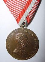 Vergoldet, ohne Stempelschneider mit Kugelöse am originalen Dreiecksband. Durchmesser 40mm.  