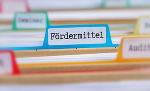 Symbolbild mit Papierakten und der Aufschrift "Fördermittel