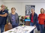 Aktionsfoto eines Workshops von Radio Helsiniki, Menschen stehen an einem Tisch. Aktionsfoto eines Workshops von Radio Helsiniki, Menschen stehen an einem Tisch.