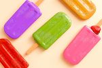 Bunte Eislutschger liegen auf einem Tisch.